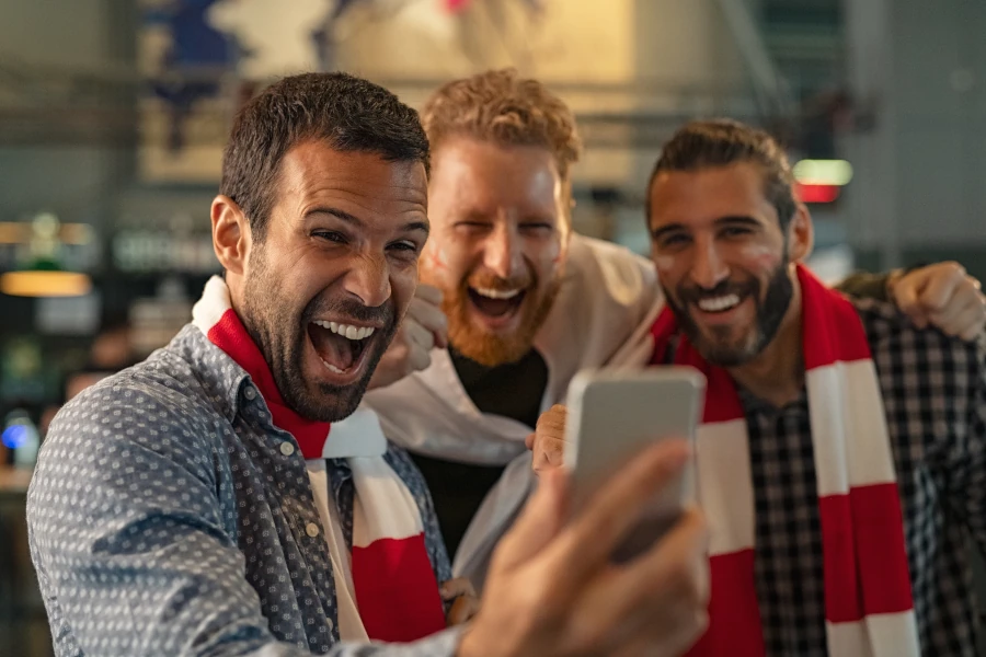 friends watching a football match together on a phone